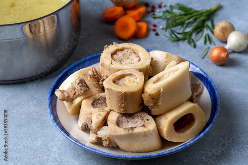 Boiled bone and broth. Homemade beef bone broth is cooked in a pot on. Bones contain collagen, which provides the body with amino acids, which are the building blocks of proteins. photo