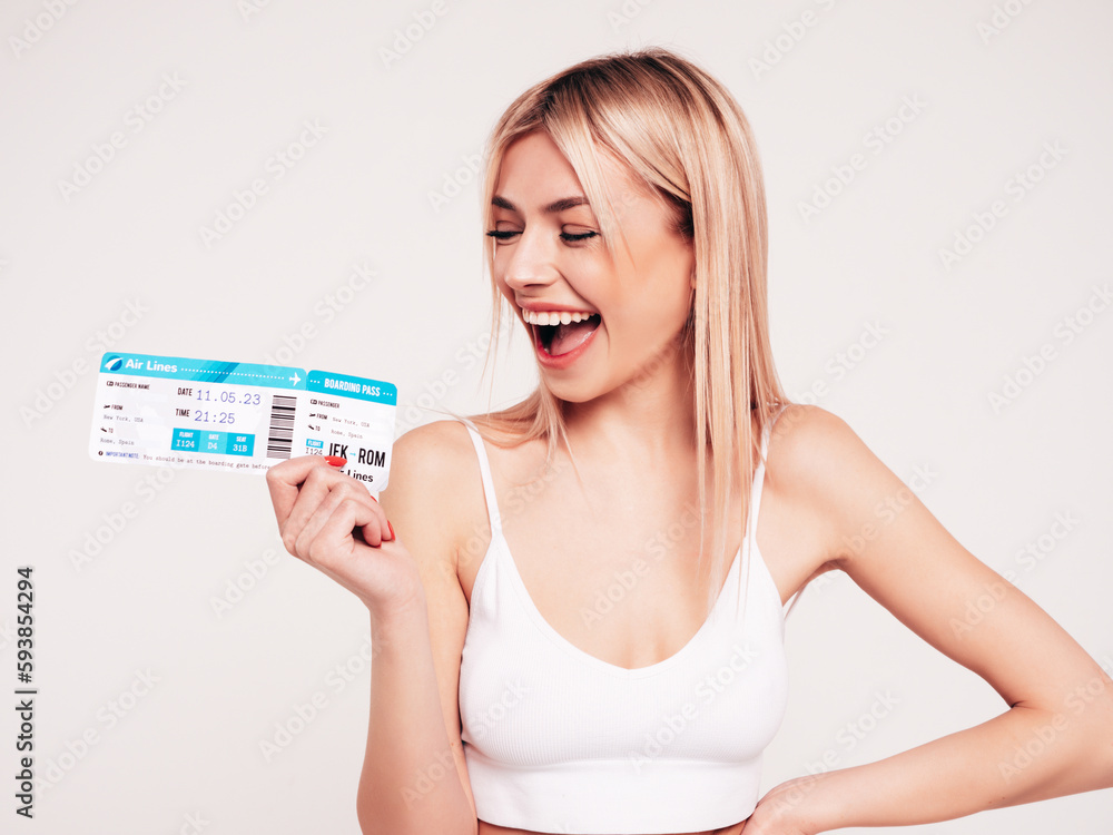 Young beautiful smiling blond female. Carefree woman isolated on white background. Positive model hold boarding pass ticket. Excited tourist. Passenger travel abroad weekend getaway air flight journey Young beautiful smiling blond female. Carefree woman isolated on white background. Positive model hold boarding pass ticket. Excited tourist. Passenger travel abroad weekend getaway air flight journey