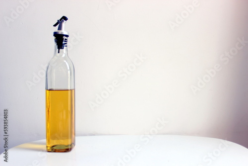 oil dispenser bottle filled with half edible refined oil for cooking and frying food items. A glass bottle with a lid to pour the oil comfortably healthy unhealthy fatty food recipe to be made from it