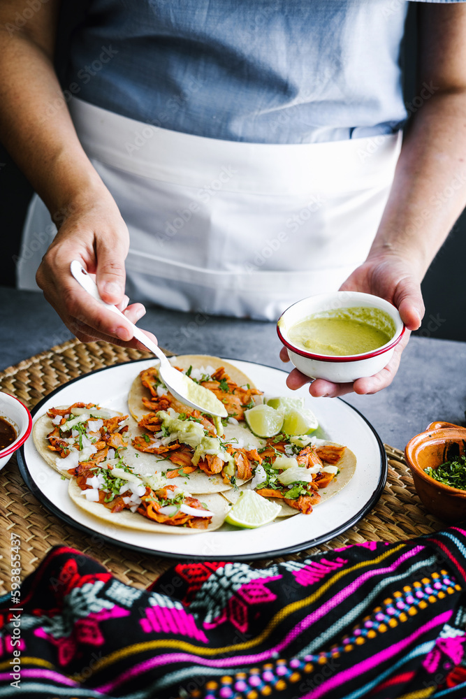 Mexican woman hands preparing tacos al pastor and eating traditional mexican food in Mexico Latin America, hispanic people Mexican woman hands preparing tacos al pastor and eating traditional mexican food in Mexico Latin America, hispanic people