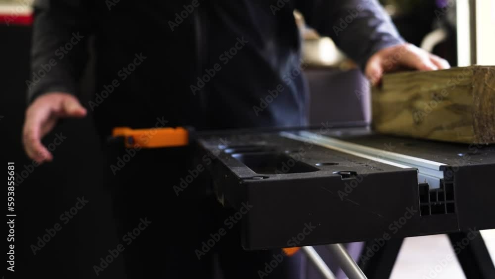 A Man preparing a table and piece of lumber to be cut with a hand saw. A Man preparing a table and piece of lumber to be cut with a hand saw.