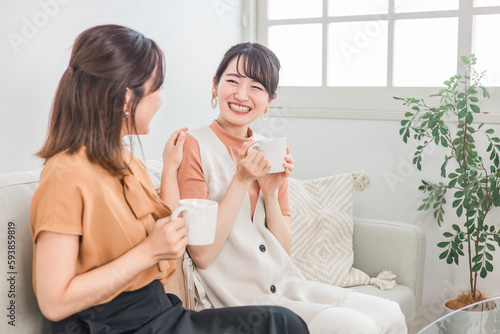 コーヒー・ホットドリンクを飲みながら友達とおしゃべりする女性
 photo