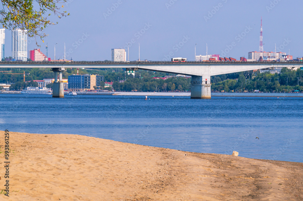 A bridge across the river in the city limits. A large bridge over a wide river. View of the transport bridge.