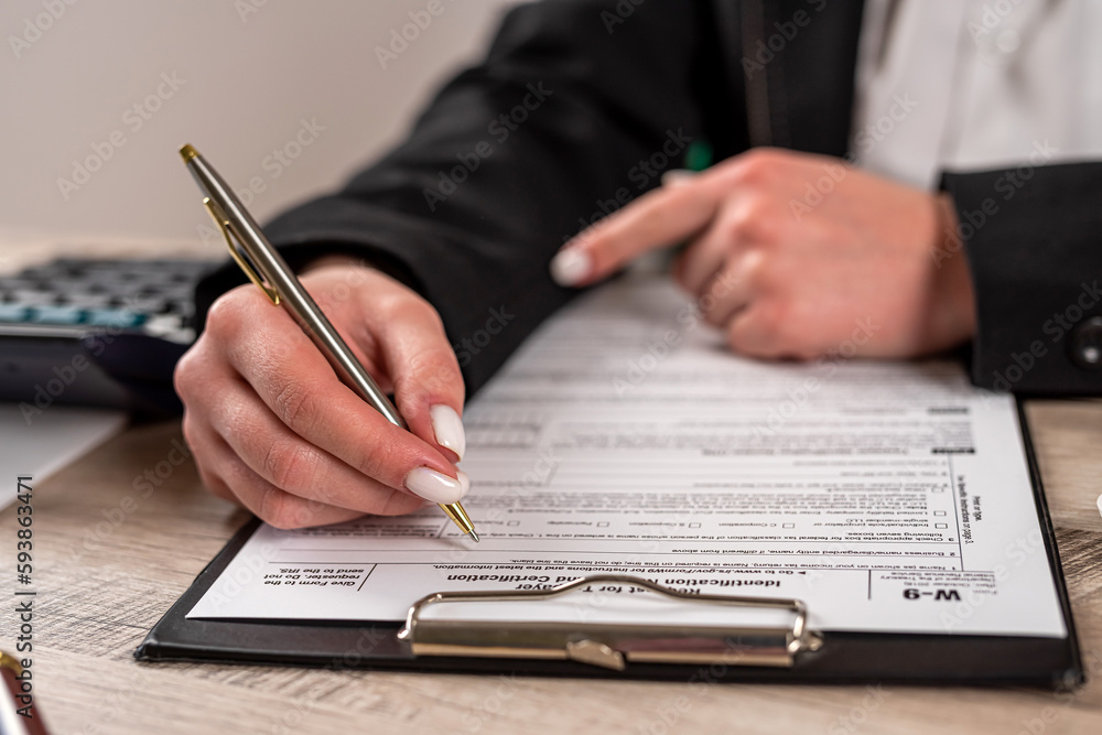 female hands filling tax form. blank empty 1040 form, deadline female hands filling tax form. blank empty 1040 form, deadline
