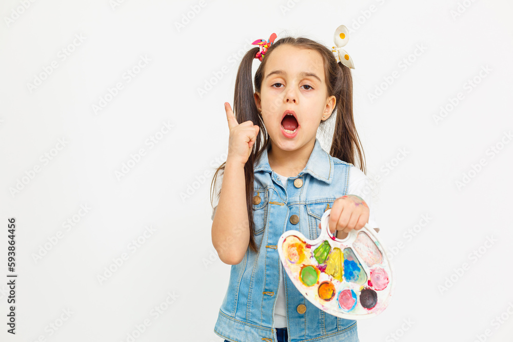 An artist on an isolated background, a little girl with paints in her hands, children's creativity. An artist on an isolated background, a little girl with paints in her hands, children's creativity.