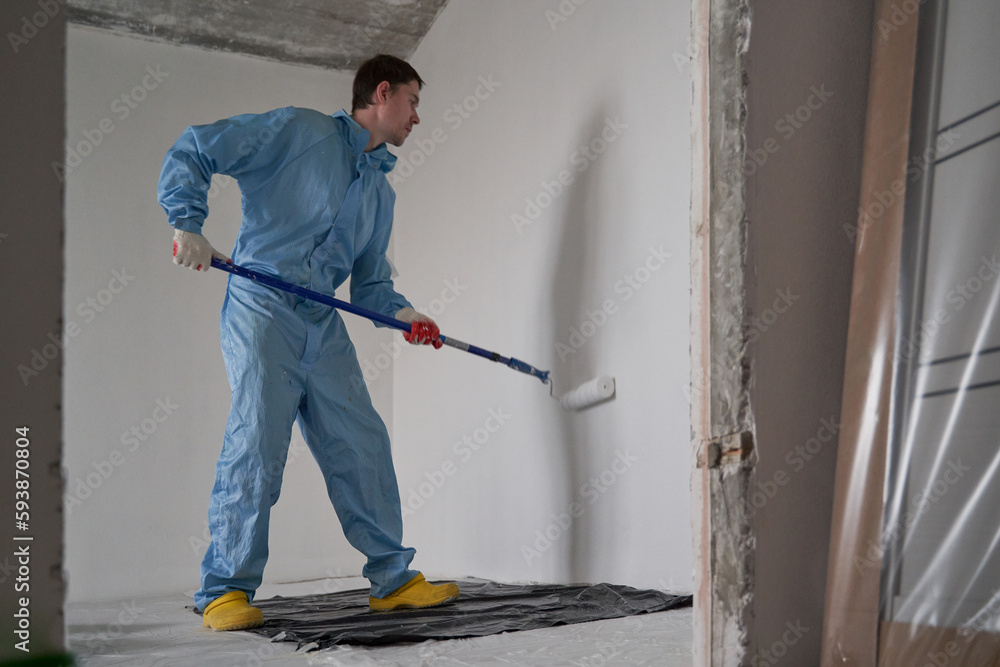 Man paints the ceiling with a roller Man paints the ceiling with a roller