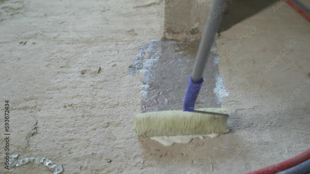 Floor primer for wall construction. Construction worker with paint