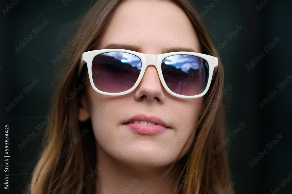 Young happy woman in summer clothes, sunglasses posing against the backdrop of a business center, taking a selfie portrait, close-up.Summer, technology concept