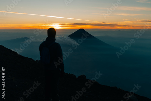 Silhouette of climber with their backpacks on top of the Acatenango volcano