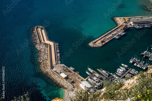 view from Ifach on Port Pesquer el Raco on the mediterranean sea in Calpe. Concrete quay, port buildings, moored sailboats, fishing boats photo