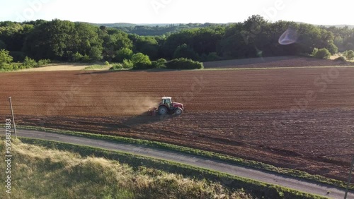 Agriculteur travaillant dans un champ au milieu de la nature grâce à un tracteur.
