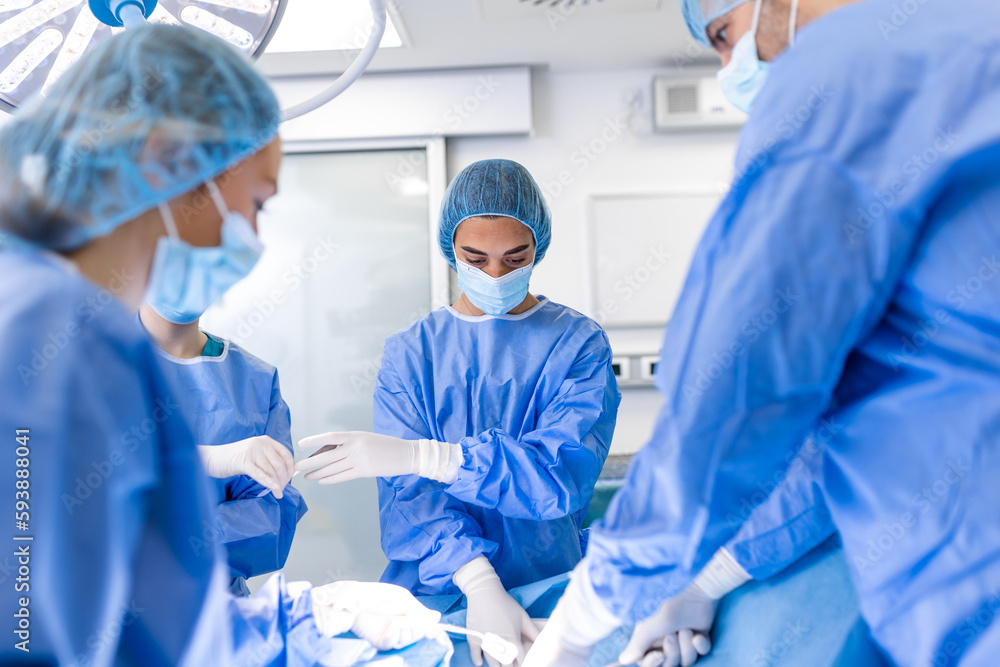 Shot in the Operating Room, Assistant Hands out Instruments to Surgeons During Operation. Surgeons Perform Operation. Professional Medical Doctors Performing Surgery. Shot in the Operating Room, Assistant Hands out Instruments to Surgeons During Operation. Surgeons Perform Operation. Professional Medical Doctors Performing Surgery.