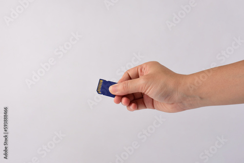 Hand holding SD card isolate on white background