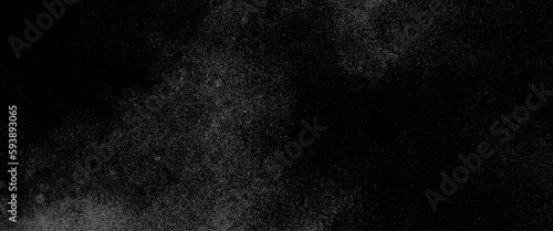 Abstract splashes of water on black background. Freeze motion of white particles, abstract splashes of milk on a black background, dust overlay textured. Grain noise particles. Snow effects pack.