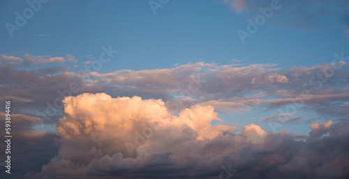 heap of lighted cumulus cloud and blue sky above, sunset scenery