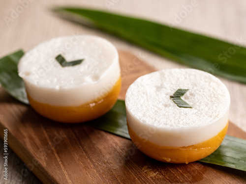 Indonesian traditional cake Kue Talam Labu Kuning served on a wooden tray. It is made of a rice flour, coconut milk and other ingredients in a mold pan called talam which means "tray" in Indonesian