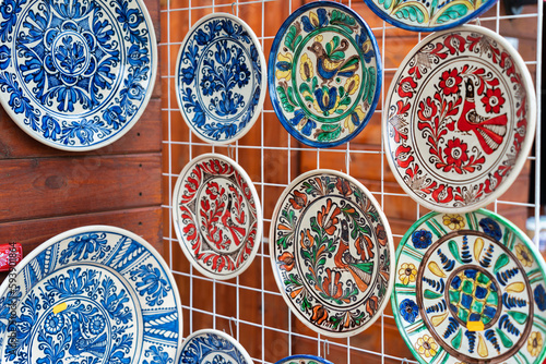 Traditional romanian handmade ceramic pottery plates with rustic authentic decoration paintings on display.