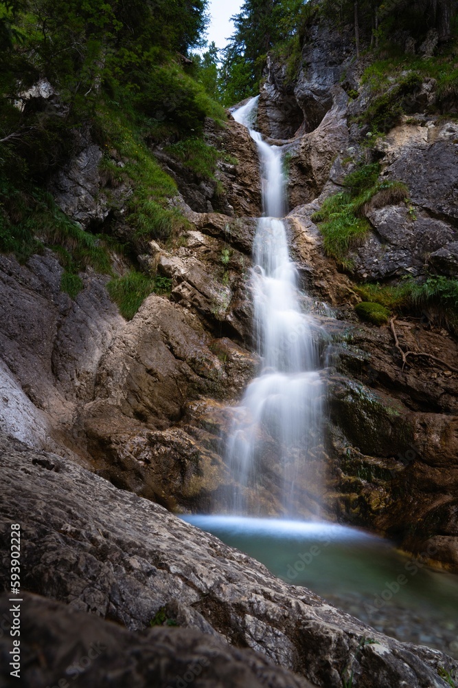 Vertical long exposure shot of a beautiful waterfall in the Bavarian Alps, Germany
