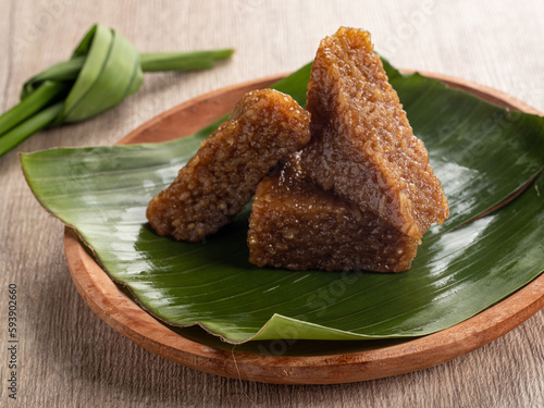 Indonesian traditional cake Kue Wajik Ketan Gula Merah or Kue Pulut Manis served on a wooden plate with banana leaf. made from a mixture of sticky rice, sugar, and coconut milk cut into a diamond shap photo