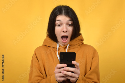 A woman with a phone in her hands is surprised