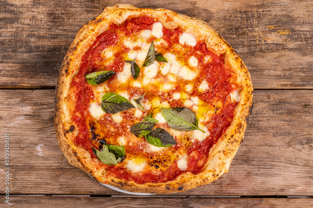 Pizza Margherita Napoletana con sugo di pomodoro, mozzarella di bufala e basilico fresco servita in una pizzeria napoletana 