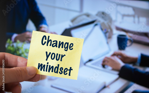 Male hand holding sticky note written Change your mindset.