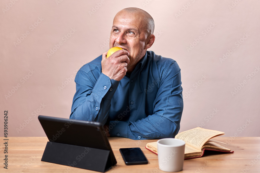 Businessman eating an apple at his desk Businessman eating an apple at his desk