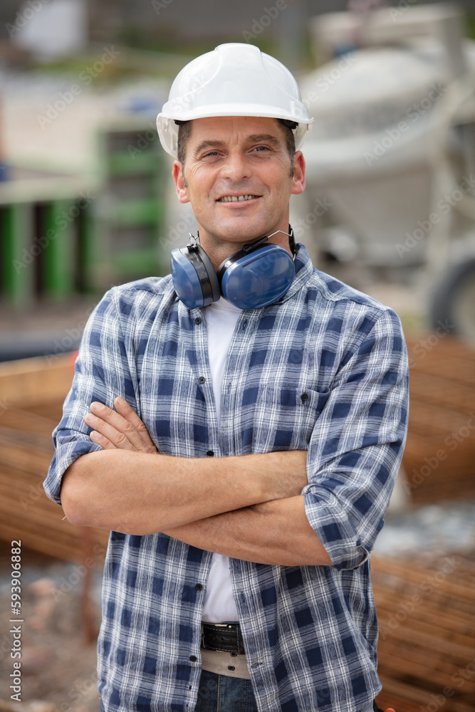 smiling builder in hardhats at construction site smiling builder in hardhats at construction site