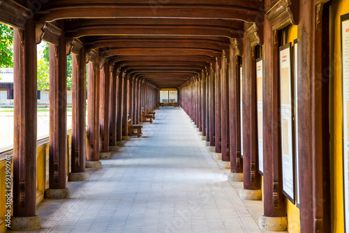Along corridor of timber beams and pillars at a temple at Hue in Vietnam