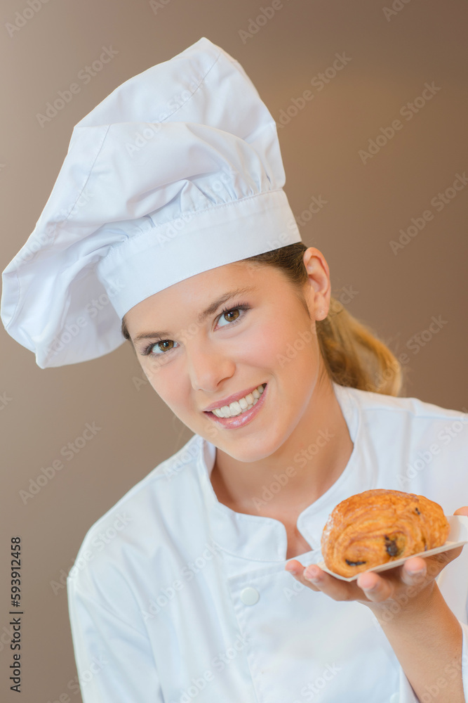 Young female chef holding a pain au chocolat Young female chef holding a pain au chocolat