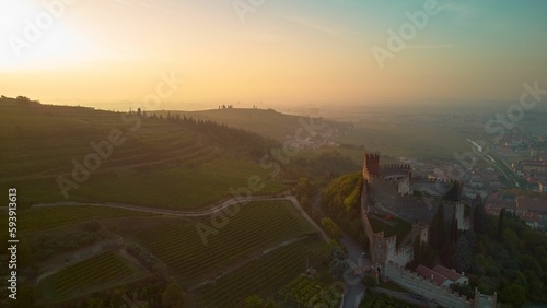 Drone shot of the Soave Castle and vineyards in Veneto region at sunset, Italy