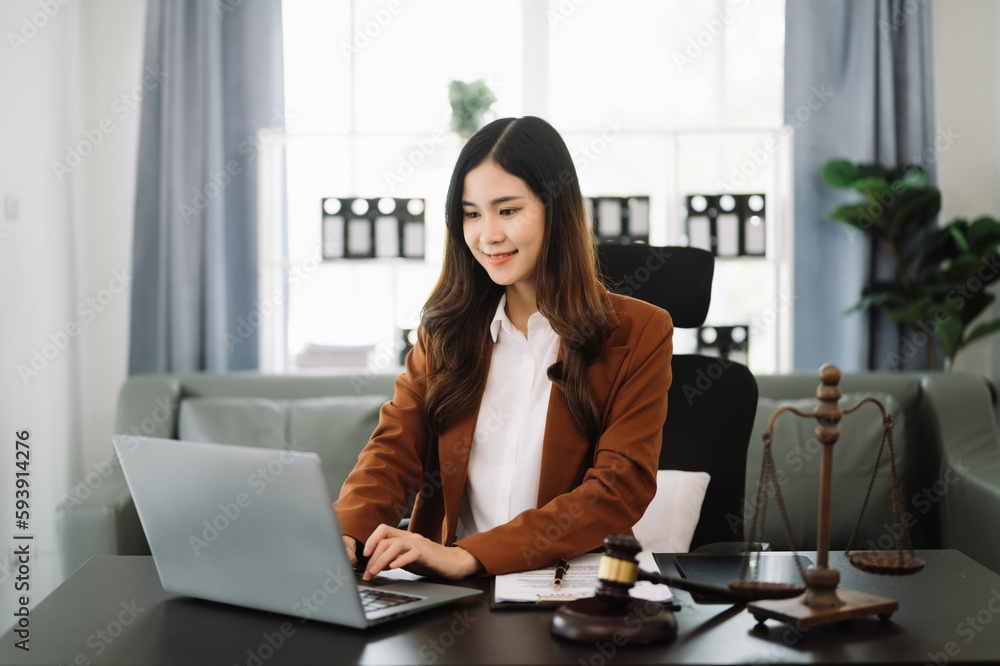 Asian lawyer woman working with a laptop and tablet in law office. Legal and legal service concept. Looking at camera.. Asian lawyer woman working with a laptop and tablet in law office. Legal and legal service concept. Looking at camera..