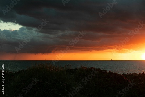 Scenic ocean sunset under dark clouds