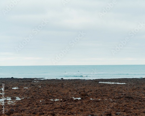 View of the seawater from the coast under the cloudy sky.