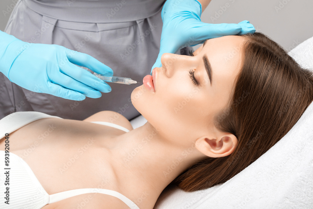 Injections for lips augmentation anti wrinkle injections on the face of a beautiful woman. Female aesthetic cosmetology in a beauty salon. Injections for lips augmentation anti wrinkle injections on the face of a beautiful woman. Female aesthetic cosmetology in a beauty salon.