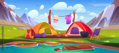 Mountain camp with tents and campfire near lake. Vector cartoon illustration of beautiful rocky landscape under blue summer sky. Travel backpacks, mat, picnic equipment on river bank. Weekend travel