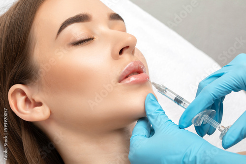 Injections for lips augmentation anti wrinkle injections on the face of a beautiful woman. Female aesthetic cosmetology in a beauty salon.