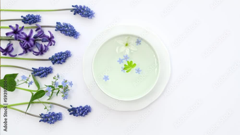 A white cup with fragrant herbal tea and flowers is the perfect choice for health and wellness. Tea time. Relaxing with herbal tea, white background, top view, vertical video A white cup with fragrant herbal tea and flowers is the perfect choice for health and wellness. Tea time. Relaxing with herbal tea, white background, top view, vertical video