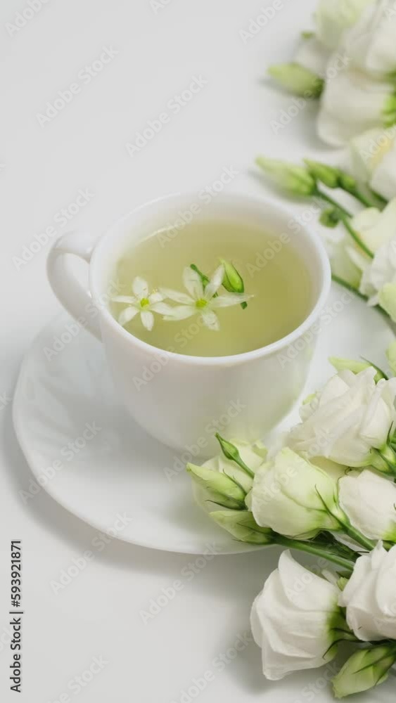 Healthy herbal tea in a white cup with medicinal herbs, spring flowers and Chinese tea rose buds Mei Gui Hua for relaxation and wellness. Floral Infusion, vertical video Healthy herbal tea in a white cup with medicinal herbs, spring flowers and Chinese tea rose buds Mei Gui Hua for relaxation and wellness. Floral Infusion, vertical video