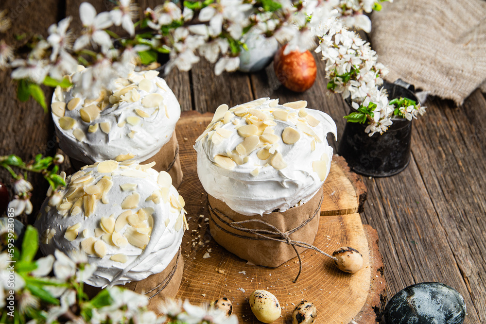 Easter cake with meringue and almond petals on a wooden background