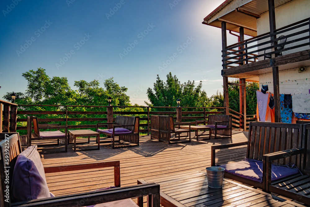 Wooden terrace with tables for outdoor dining. a dining room. Wooden terrace with tables for outdoor dining. a dining room.