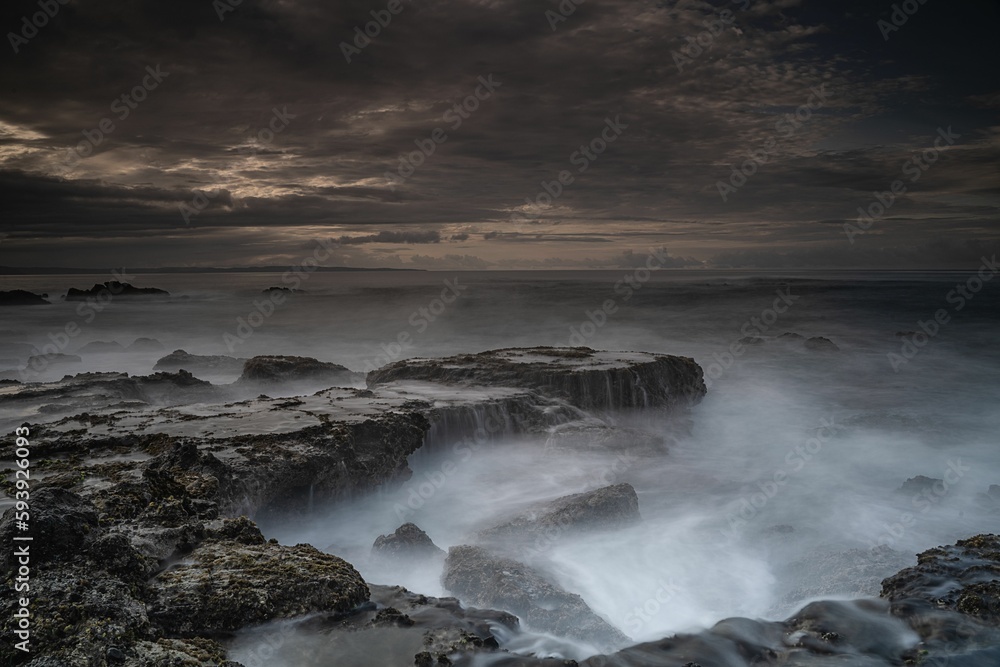 Breathtaking view of Karang Bokor Sawarna in Indonesia under dark cloudy sunset sky, long exposure Breathtaking view of Karang Bokor Sawarna in Indonesia under dark cloudy sunset sky, long exposure