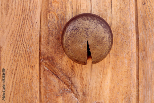Door wooden handle in the shape of a circle on a light wooden background, close-up