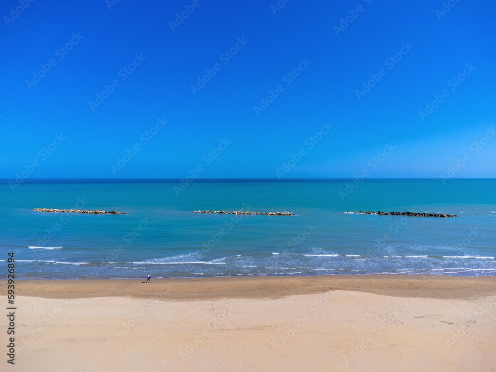 Aerial view landscape Italy Pescara. Empty beach and sea, waves, sand. Photo from a drone. Blue sky.