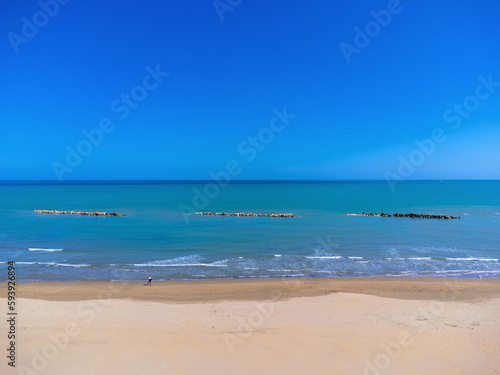 Obraz na płótnie Aerial view landscape Italy Pescara. Empty beach and sea, waves, sand. Photo from a drone. Blue sky. w salonie
