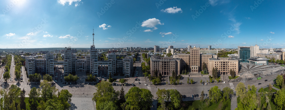 Aerial wide view on Derzhprom and northern Karazin National University buildings on Freedom Square with greenery and blue sunny sky in Kharkiv, Ukraine