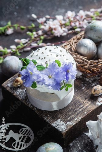 Easter cake with meringue and violets on a dark background