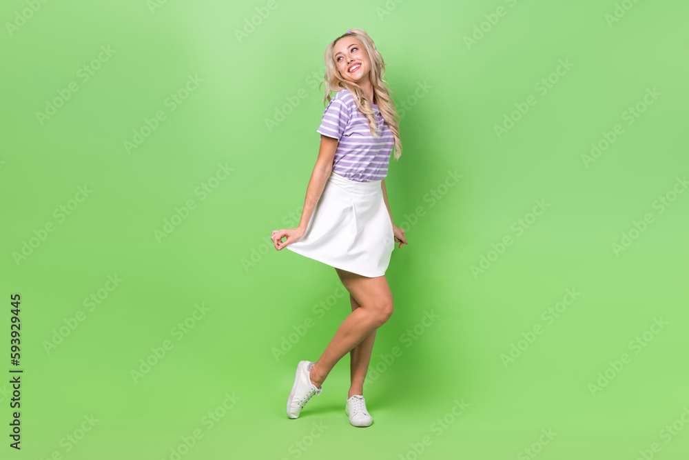 Full length photo of dreamy charming lady dressed purple t-shirt looking empty space isolated green color background Full length photo of dreamy charming lady dressed purple t-shirt looking empty space isolated green color background