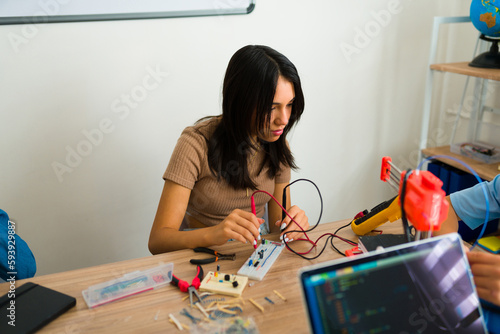 Teen smart student making a breadboard during a robotics course photo