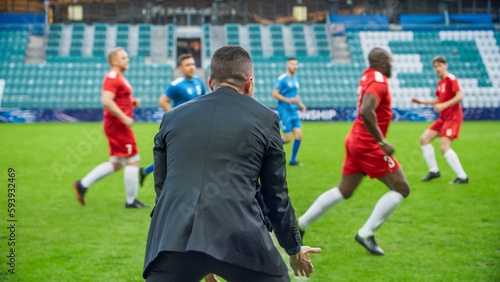 Professional Soccer Football Match Championship on Stadium with Disappointed Coach Training Talented Players. Teams Attacks  Plays in Pass. Major League Cup World Tournament Concept. Back View.
